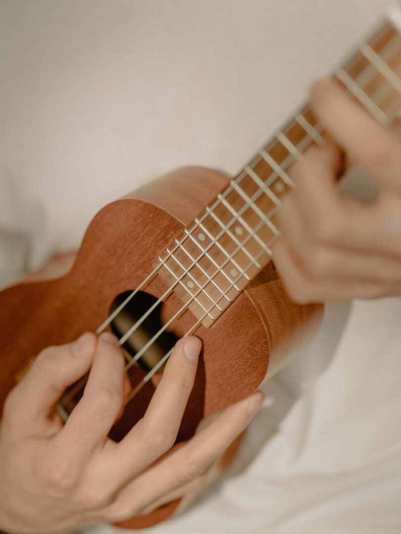 A person playing an instrument on the ukulele.