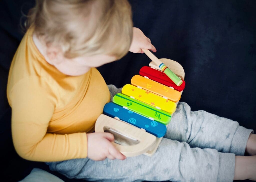 A child playing with a toy xylophone.